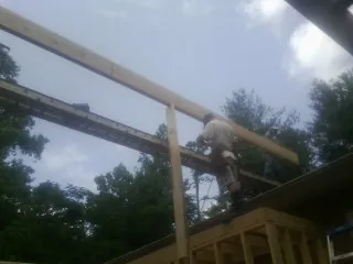 Carpenter setting a ridge beam over a new addition frame — Ice Dam Removal by Roofing Brothers in Helotes