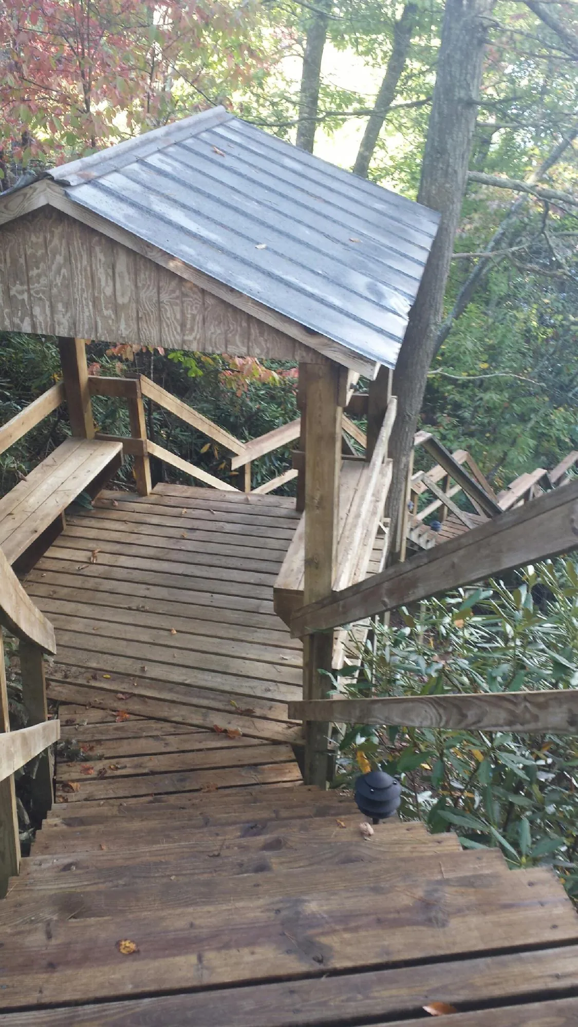 Metal roofed shelter over wooden steps on a wooded walkway — Skylight Repair & Installation work by our crew in Helotes