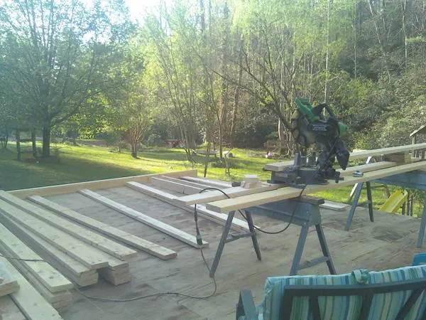 Miter saw and framing lumber on a deck under construction in Helotes