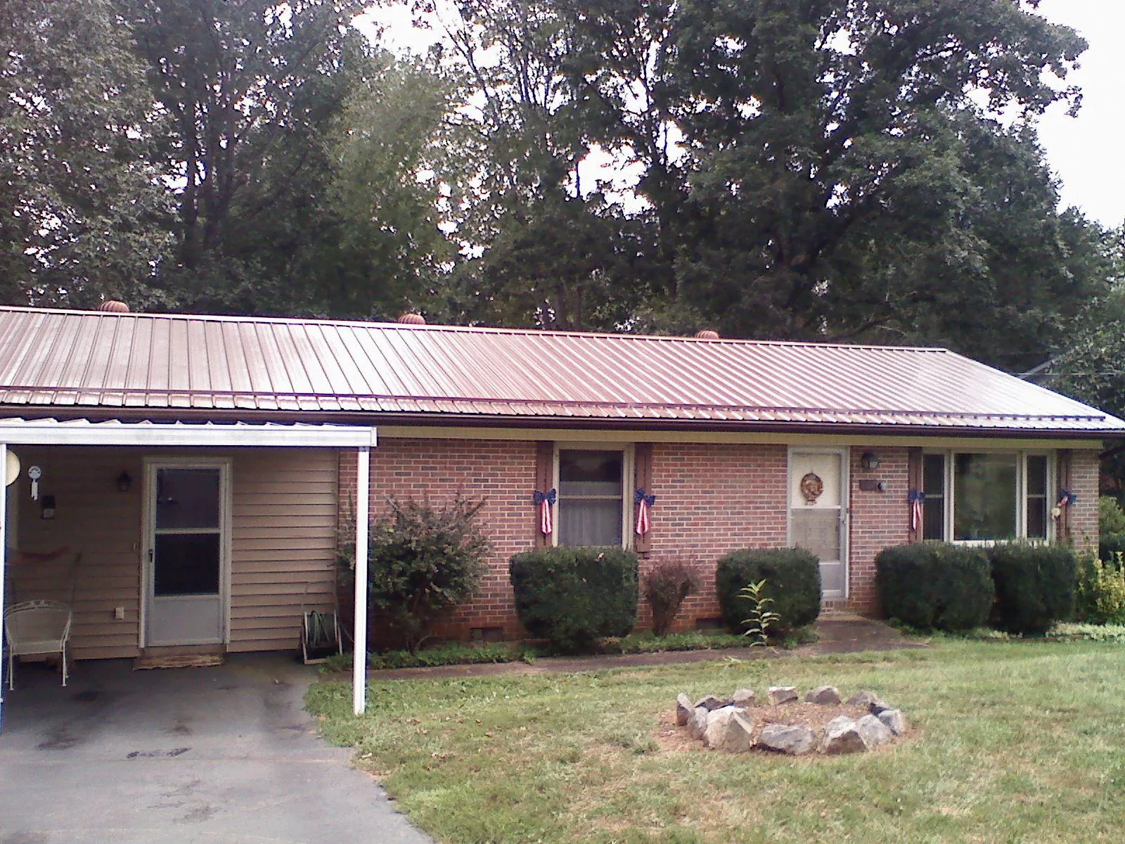 Bronze metal roof and carport on a brick ranch home — Roof Repair work by our crew in Helotes