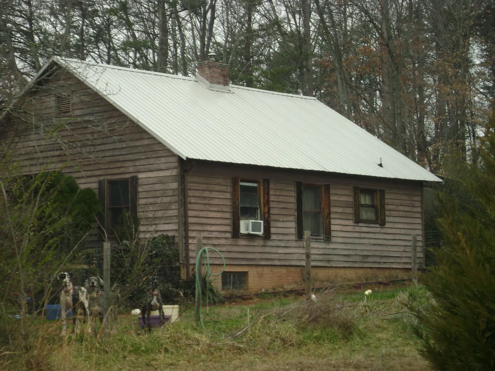 White metal roof on an old wood sided farmhouse, from a Metal Roof Installation job in Helotes